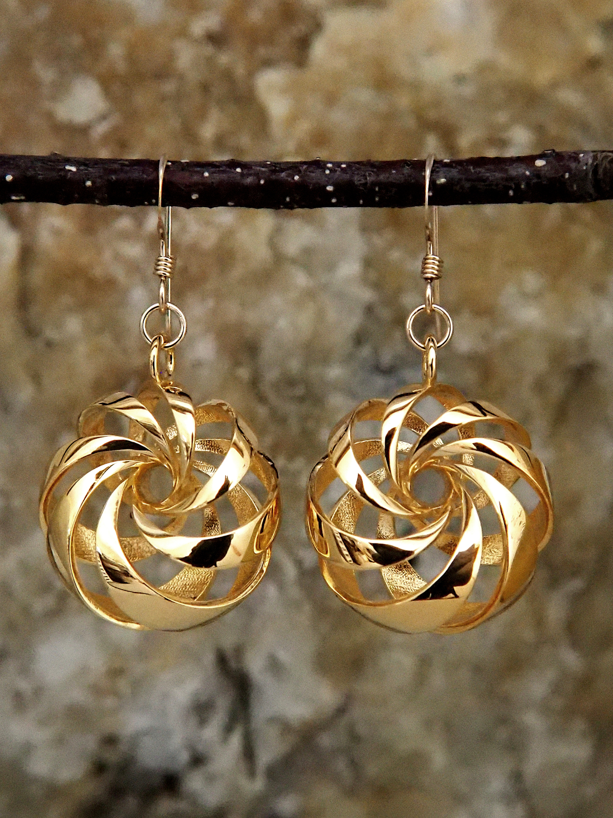 Gold-plated brass earrings shaped like diagonally-banded tori