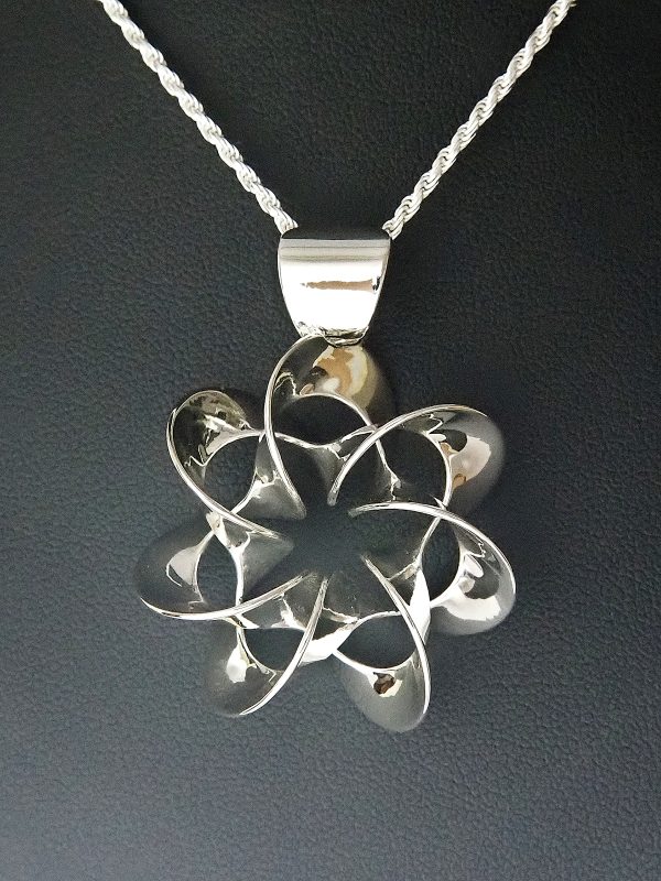 A flower-like polished silver pendant on a silver chain