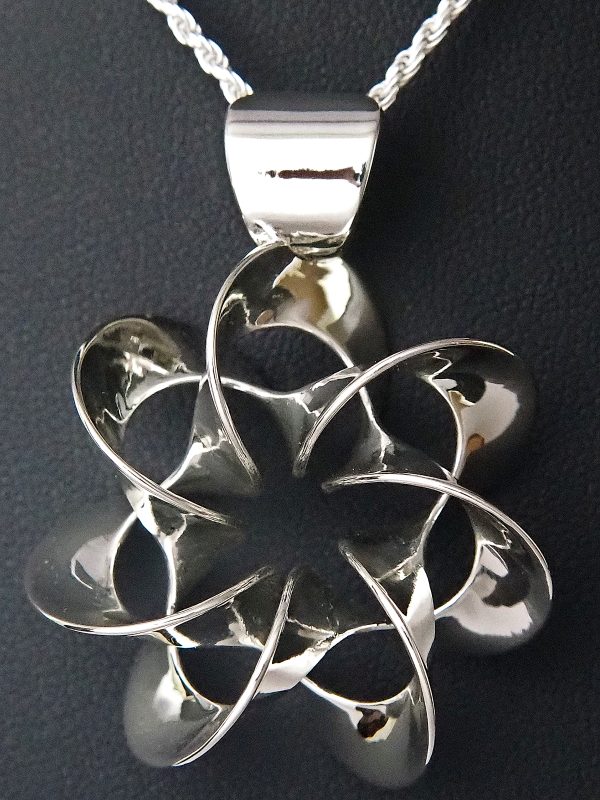 A flower-like polished silver pendant on a silver chain